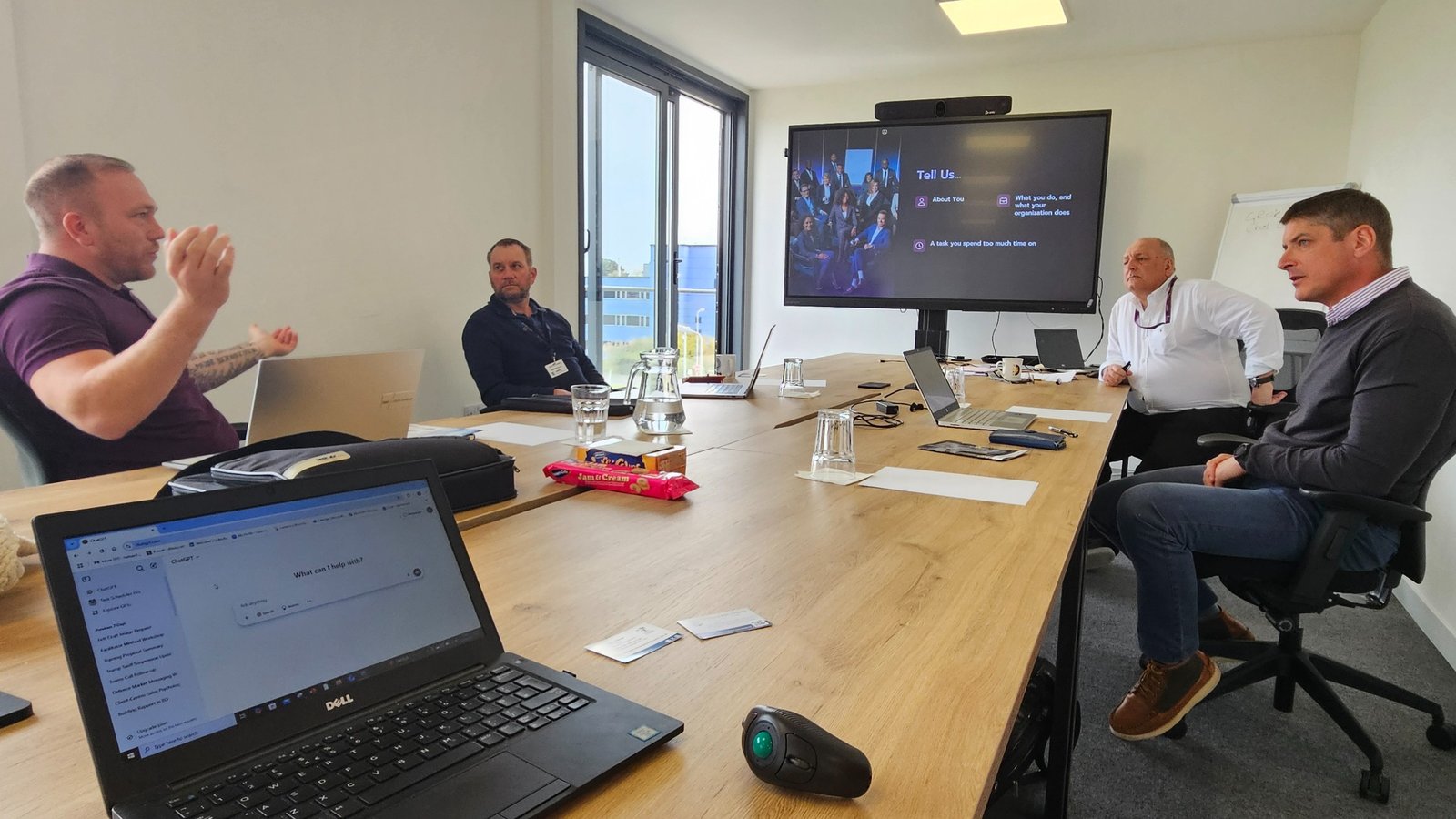 Hands-on AI workshop roundtable with laptops and shared screen